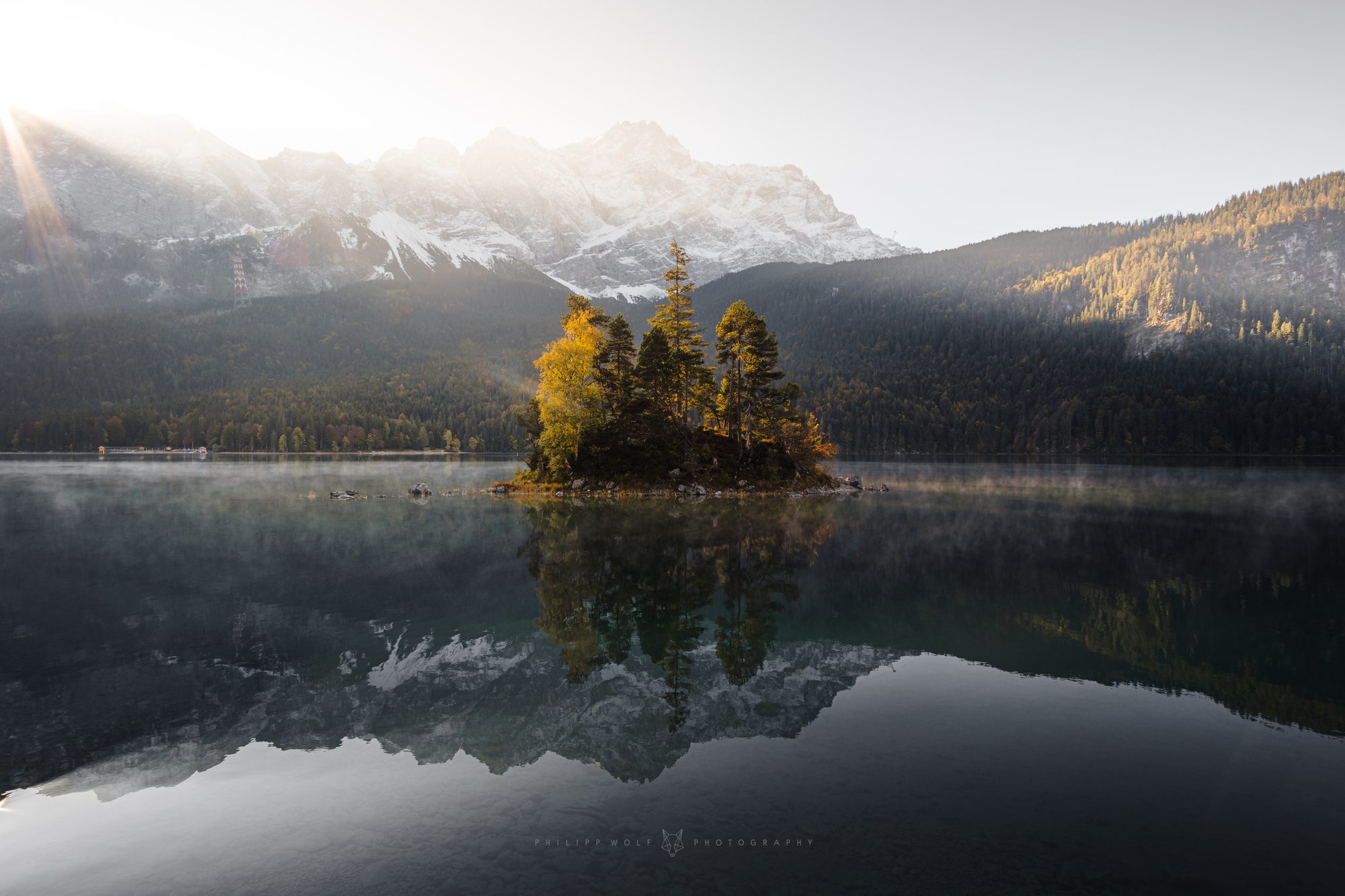 Kleine Insel im Eibsee mit Herbstlaub vor dem Zugspitzmassiv