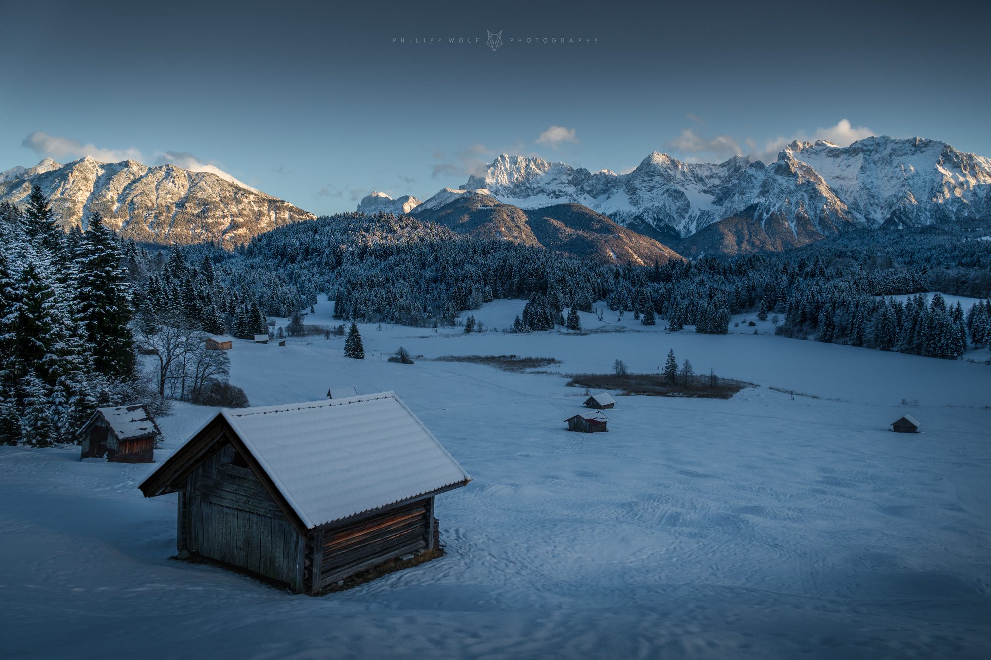 Schneebedeckte Hütten am Geroldsee vor dem Karwendelgebirge