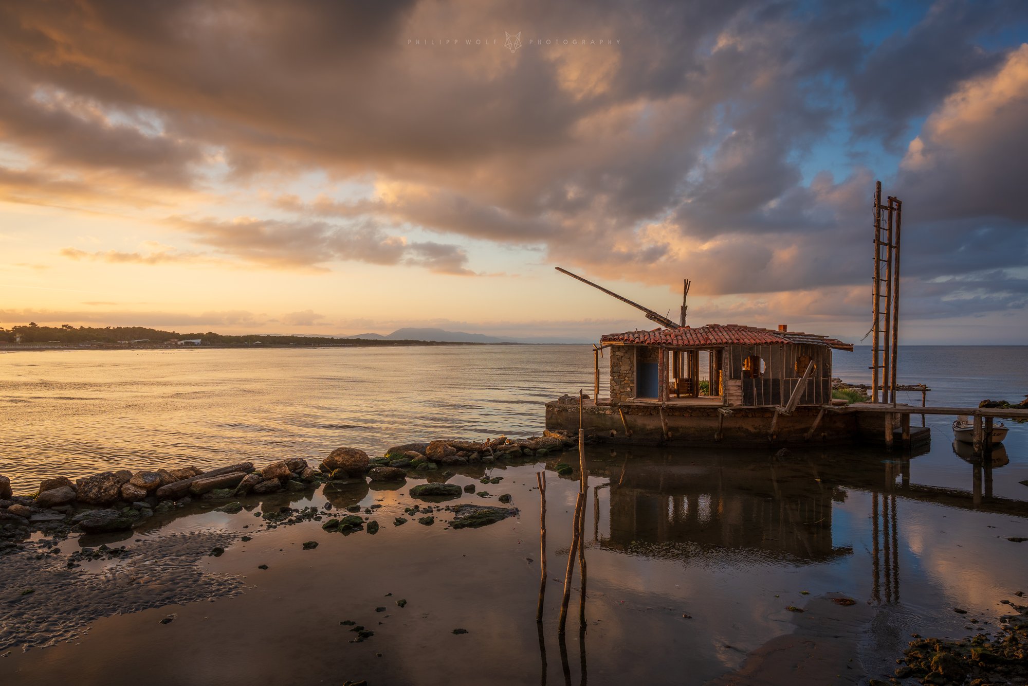 Alte Fischerhütte auf Stelzen in einer Lagune im Abendlicht